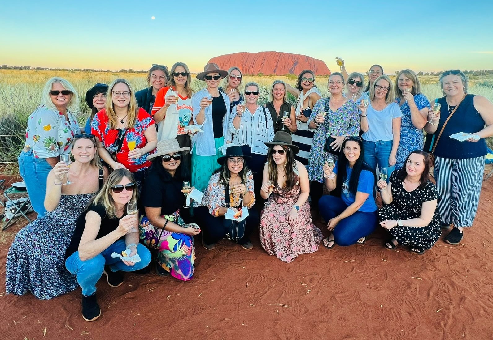 The 2026 Ladies HQ Uluru group together in the sunshine with Uluru behind them